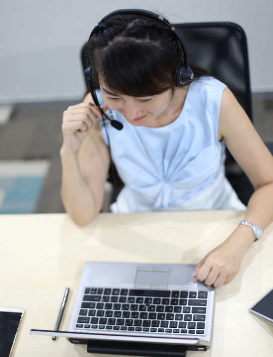Help Desk Recruiting image of Asian woman at desk with computer and headset
