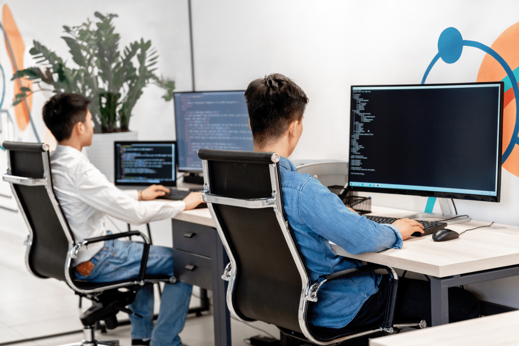 Two colleagues working at adjacent computer desks